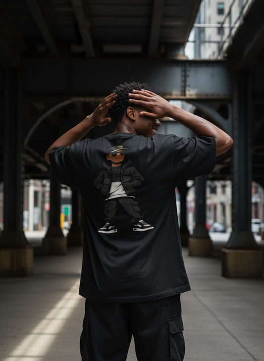 Person wearing a black t-shirt with a graphic design, standing under a bridge.