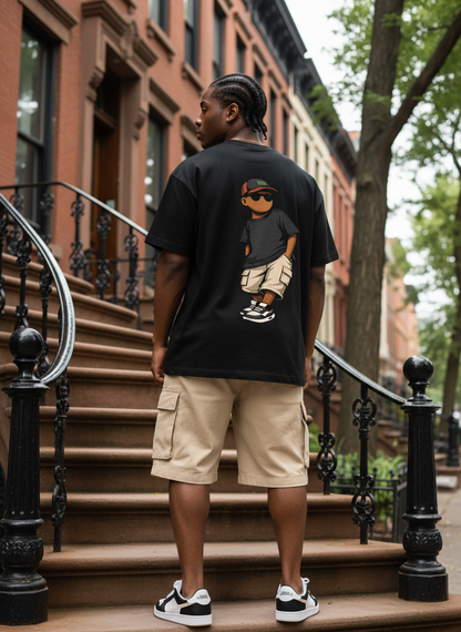 Person wearing a black t-shirt with a graphic design on a city street.